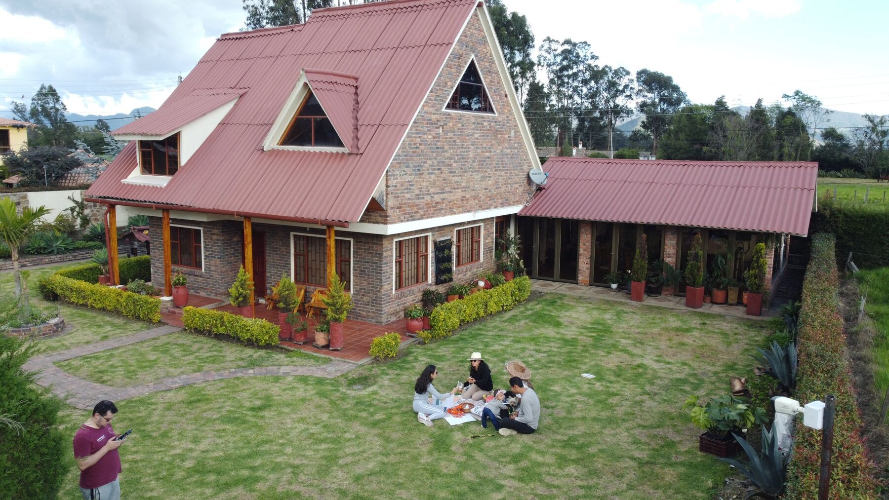 Casa Hojarasca: casa de ladrillo con techo a dos aguas y amplio jardín