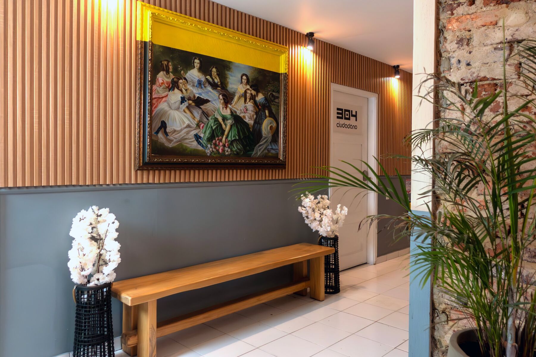 Pasillo con paneles de madera, banca y pintura clásica en marco dorado