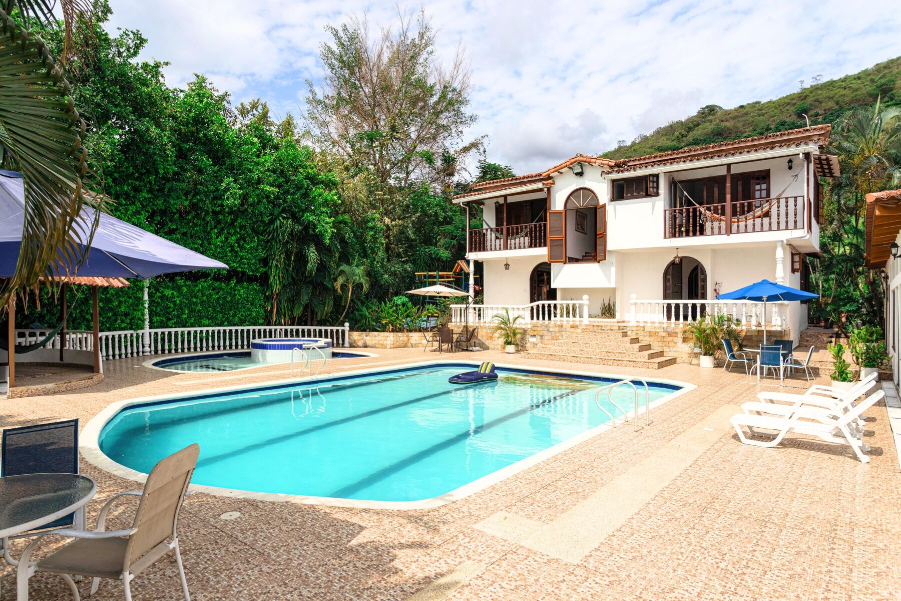 Villa Rinconada: casa blanca de balcones en madera junto a la piscina